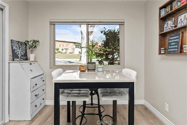 dining room with light wood-style flooring and baseboards