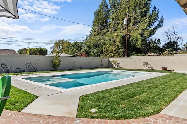 view of pool featuring a yard, a patio area, a pool with connected hot tub, and a fenced backyard