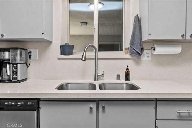 kitchen with dishwasher, white cabinets, and a sink