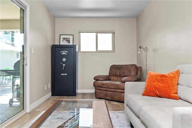 living area with baseboards and wood finished floors