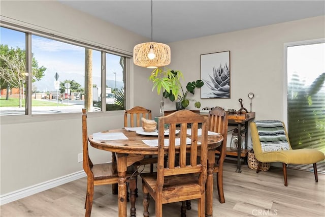 dining space featuring baseboards and light wood-style flooring