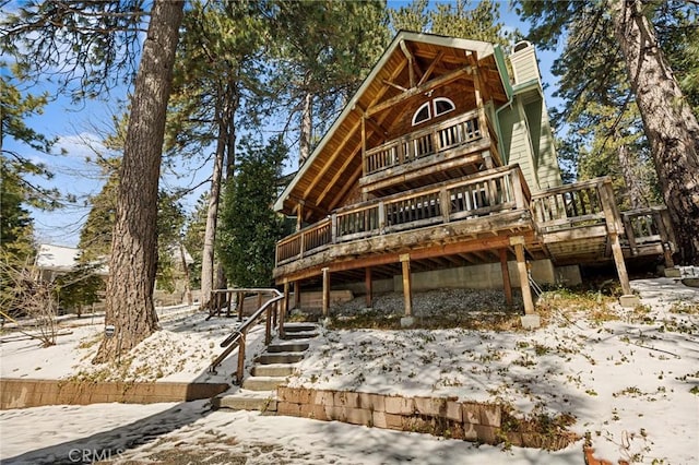 view of front of house featuring stairs, a chimney, and a wooden deck