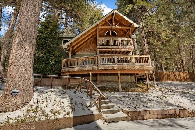 view of front facade featuring a deck, fence, and stairs