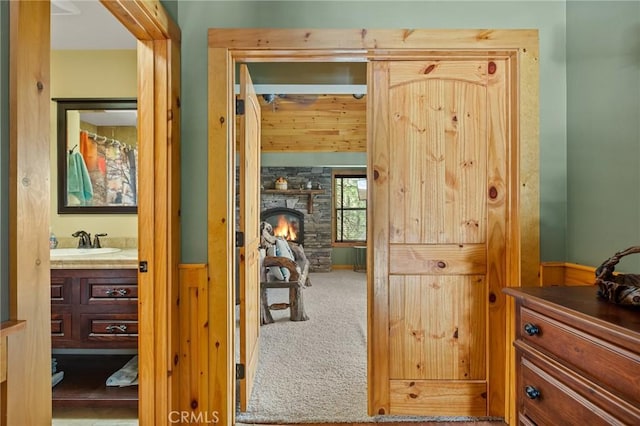 corridor with carpet floors and a sink