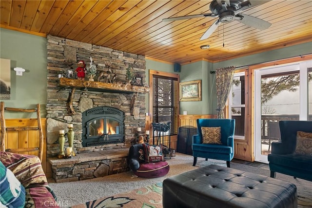 carpeted living area featuring wood ceiling, a fireplace, and a ceiling fan