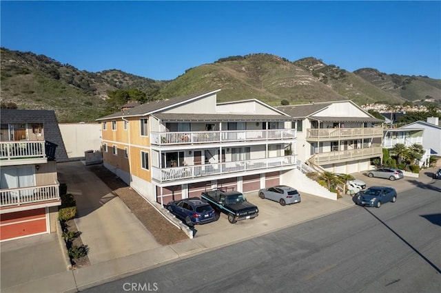 view of front facade with uncovered parking and a mountain view