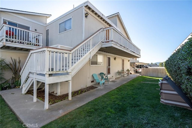 rear view of property with stairs, a patio, a lawn, and fence