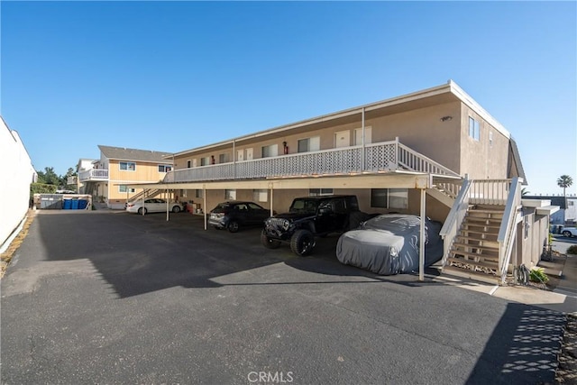 covered parking lot featuring stairway