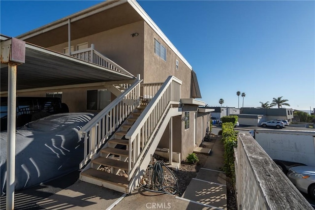 view of side of property with stairway and stucco siding