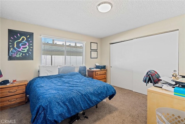 carpeted bedroom featuring a closet and a textured ceiling