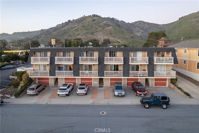 view of property with uncovered parking and a mountain view