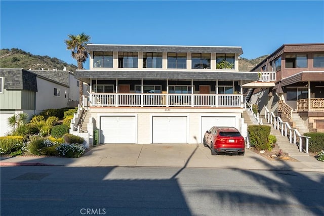 view of front of house with a garage, stairs, and concrete driveway