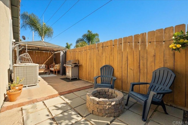 view of patio with an outdoor fire pit, area for grilling, fence, a gazebo, and central air condition unit