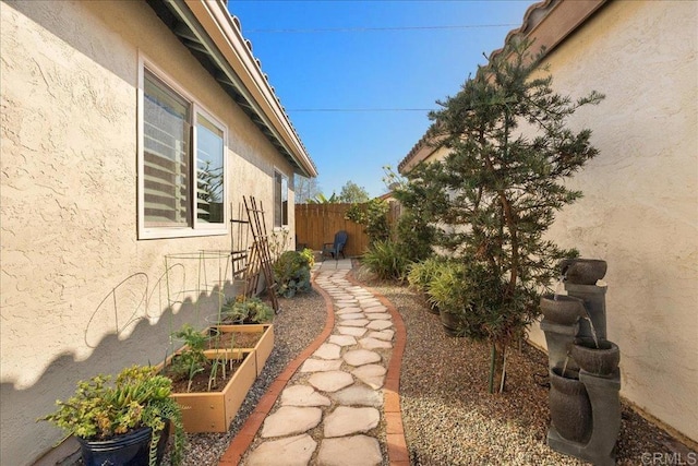 view of yard with fence and a garden