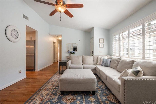 living room with baseboards, visible vents, a ceiling fan, wood finished floors, and vaulted ceiling