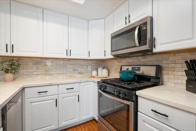 kitchen featuring stainless steel appliances, light wood-type flooring, and white cabinetry