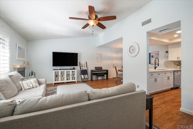 living area with ceiling fan, wood finished floors, and visible vents