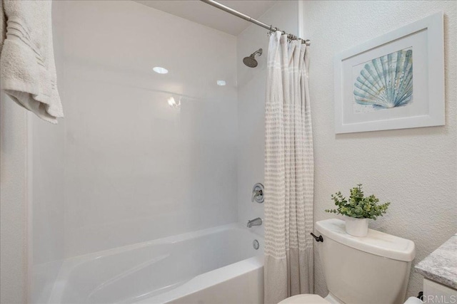 full bathroom with a textured wall, shower / tub combo, and toilet