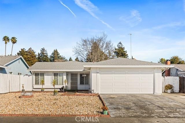 single story home with a garage, concrete driveway, and fence