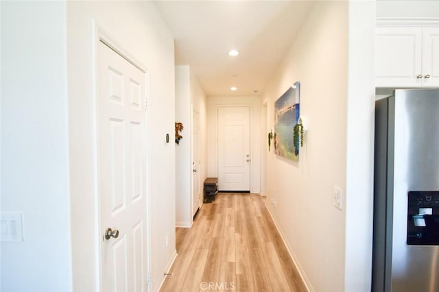 hallway featuring recessed lighting, light wood-style flooring, and baseboards