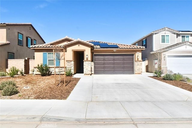 view of front of home with a garage, stone siding, concrete driveway, and solar panels