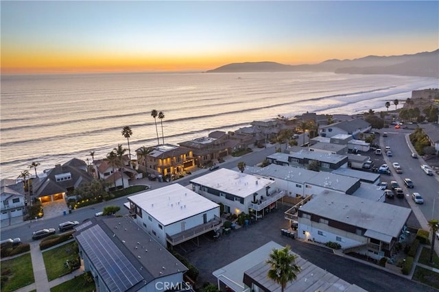 drone / aerial view with a residential view, a beach view, and a water and mountain view