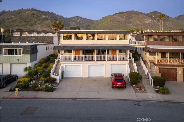 view of front of home with a garage, driveway, stairway, and a mountain view