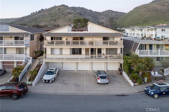 exterior space with driveway, an attached garage, and a mountain view