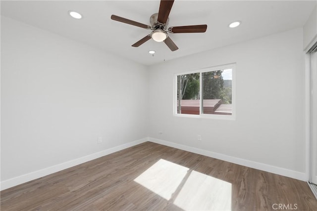 empty room with recessed lighting, wood finished floors, baseboards, and ceiling fan