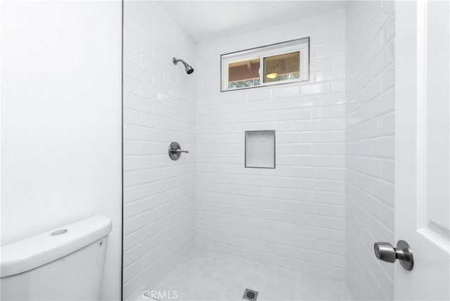 full bath with a tile shower and toilet