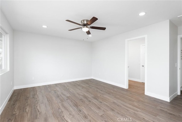 spare room featuring recessed lighting, baseboards, and wood finished floors