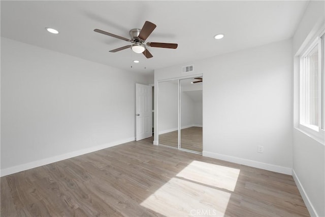 unfurnished bedroom with recessed lighting, wood finished floors, and baseboards
