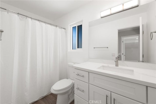 bathroom with curtained shower, toilet, vanity, and wood finished floors