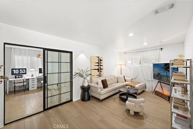 living area with visible vents, wood finished floors, and recessed lighting