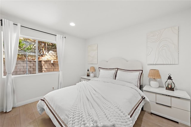 bedroom with light wood finished floors, baseboards, and recessed lighting
