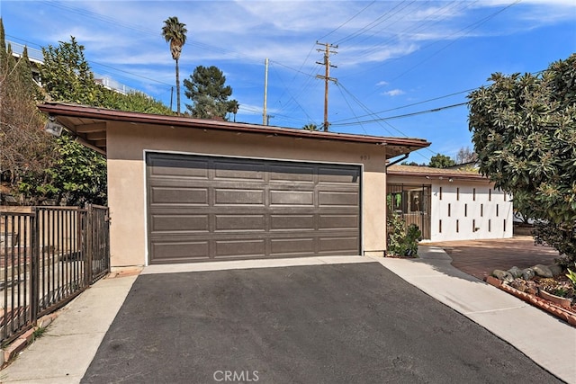 garage with driveway and fence