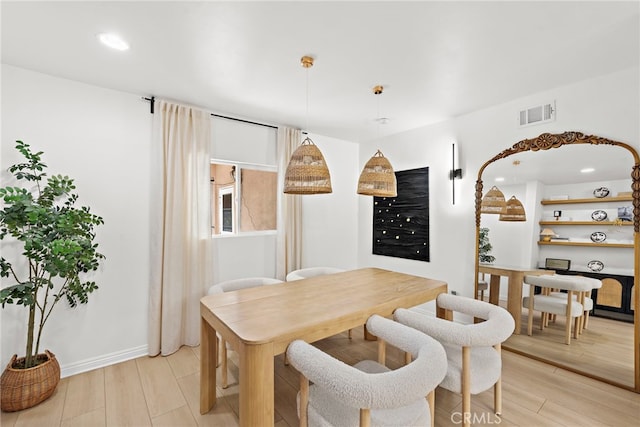 dining area with light wood-type flooring, visible vents, and recessed lighting