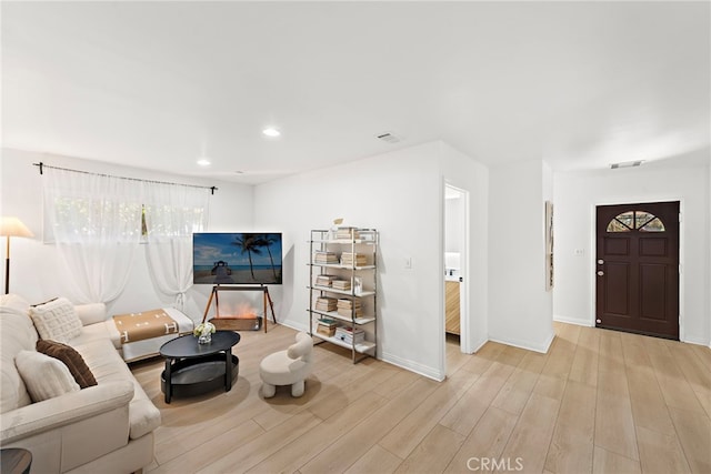 living room with baseboards, wood finished floors, visible vents, and recessed lighting