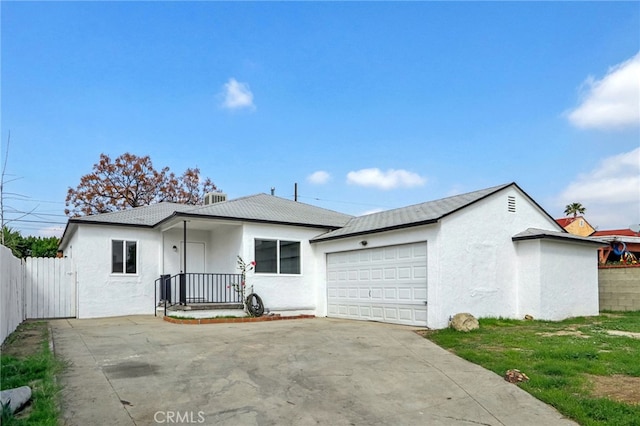 ranch-style home featuring driveway, an attached garage, fence, and stucco siding