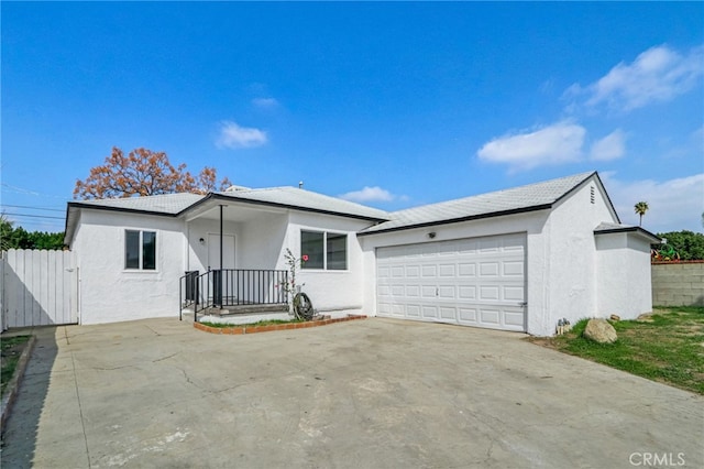 ranch-style home with a garage, concrete driveway, fence, and stucco siding