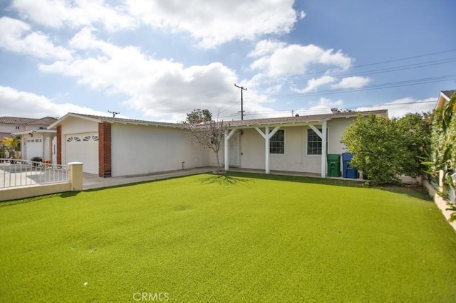 view of front of house with a garage, a front yard, and stucco siding