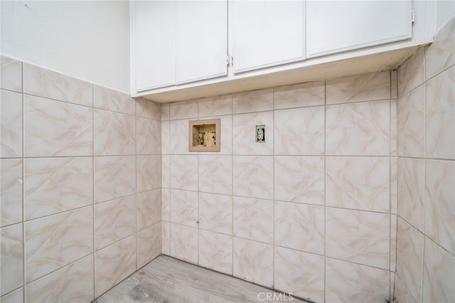 clothes washing area featuring washer hookup and cabinet space