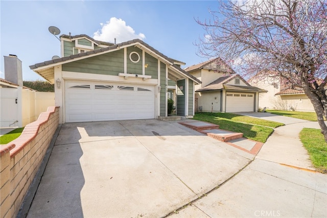 view of front of property featuring driveway, an attached garage, and fence