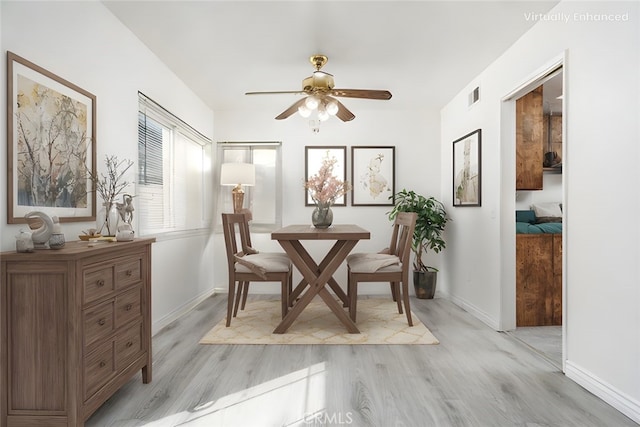 dining space with light wood-style flooring, visible vents, ceiling fan, and baseboards