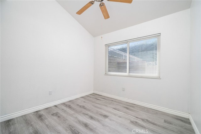 empty room featuring light wood-type flooring, baseboards, vaulted ceiling, and a ceiling fan