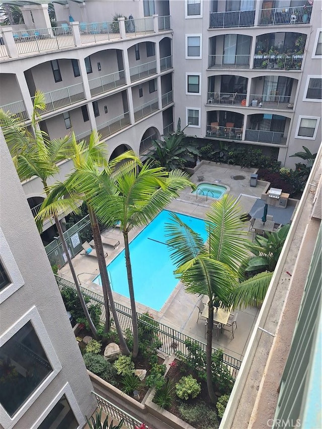 view of pool with a hot tub