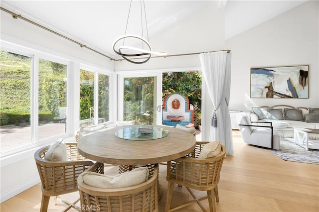 sunroom / solarium with vaulted ceiling, a wealth of natural light, and a notable chandelier