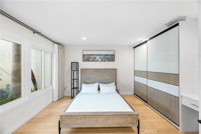 bedroom featuring baseboards, light wood-style flooring, and recessed lighting