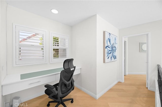 office with light wood-type flooring and baseboards