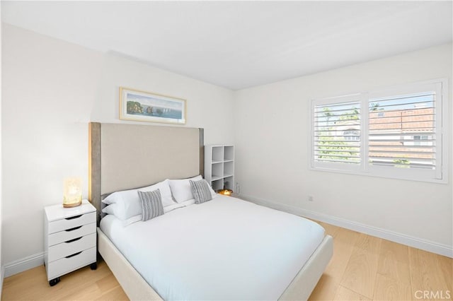 bedroom with baseboards and light wood finished floors